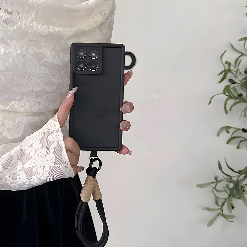 Person holding a black phone case with a lanyard on a light background